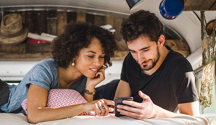 En man och en kvinna tittar på en mobiltelefon